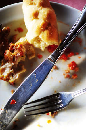Food remains after dinner on dirty plateの写真素材