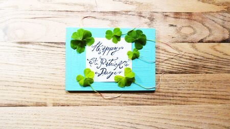 St. Patrick's Day word text with clover shamrock leafs around lucky plant on a wooden background template image photo pictureの写真素材