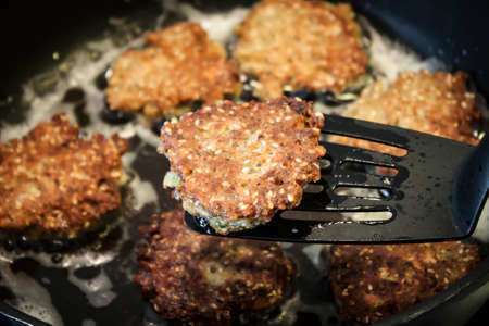 homemade falafel frying on black panの写真素材