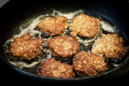 homemade falafel frying on black panの写真素材