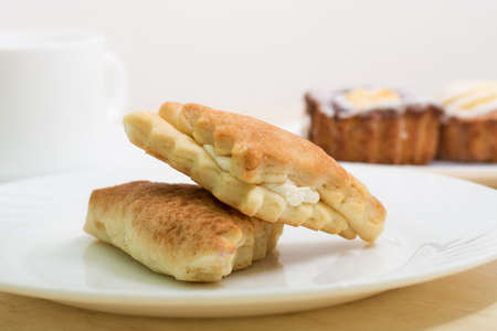 Two tasty vanilla cakes with cup of teaの写真素材