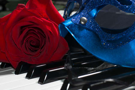 Beautiful composition of carnaval mask,piano keys and red roseの写真素材