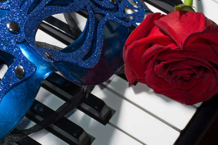 Beautiful composition of carnaval mask,piano keys and red roseの写真素材