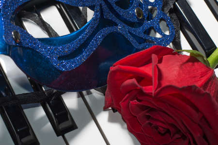 Beautiful composition of carnaval mask,piano keys and red roseの写真素材