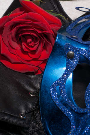 Composition of erotic black corset, red rose and blue maskの写真素材