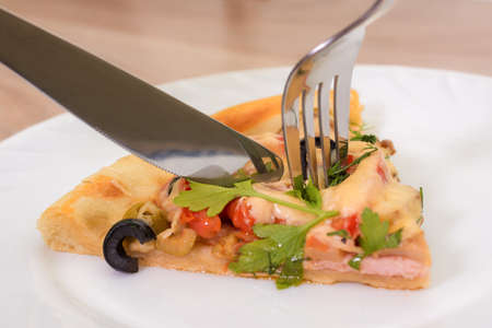 national italian food - pizza. homemade, with salami,  cheese, tomatoes, black and green olive on white plateの写真素材