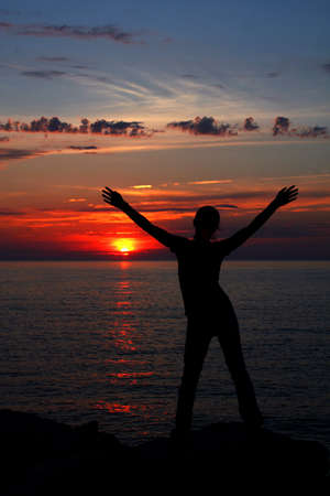 Silhoette of young girl with hands extended.の写真素材
