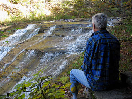 Man relaxing by waterfallの写真素材
