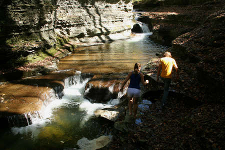Young couple walking along edge of waterfall.の写真素材
