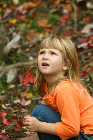 Little girl outdoors looking up towards sky.の写真素材