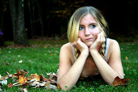 Young girl laying in grass thinking.の写真素材