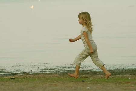 Little girl running at beach.の写真素材