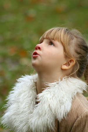 Little girl looking up wearing winter coat.の写真素材