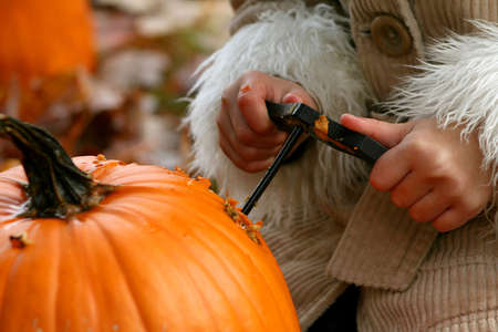 Little girls hands decorating pumpkin.の写真素材