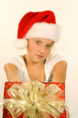 Young girl wearing santa hat holding giftの写真素材