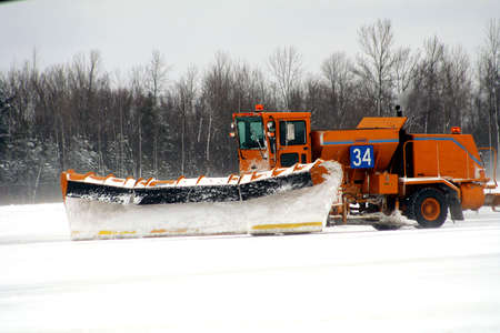 Snow plow removing snow at airportの写真素材