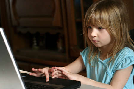 Little girl learning to use laptop computerの写真素材