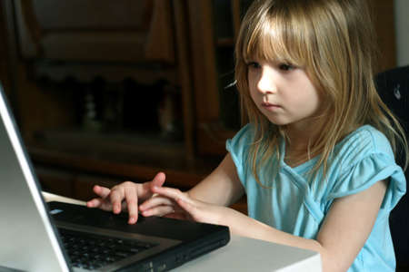 Little girl learning to use laptop computerの写真素材