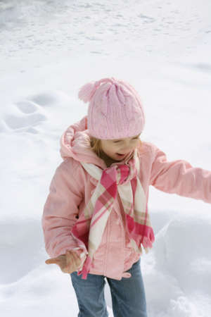 Little girl dressed in pink playing in snowの写真素材