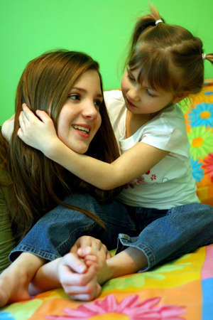 Two sisters sharing a hugの写真素材