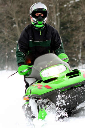 Teenager driving snowmobile in winterの写真素材
