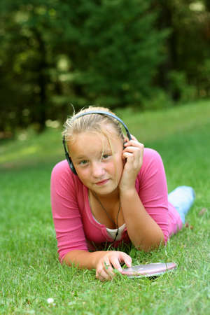 Preteen girl outdoors listening to musicの写真素材