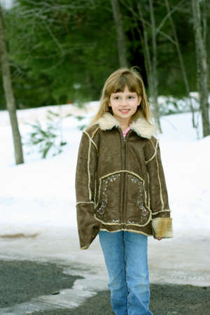 Little girl walking outdoors in winter wearing coatの写真素材
