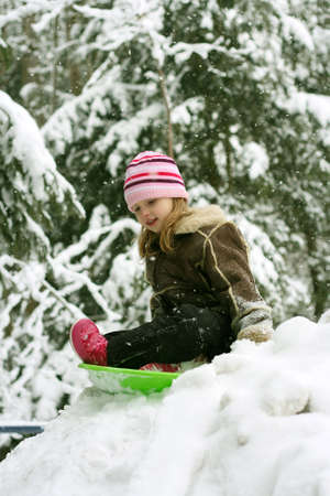 Little girl sledding in winterの写真素材