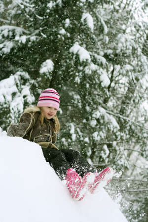 Little girl playing in snow on winter day