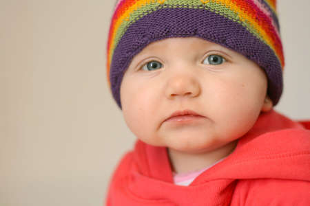 Close up of cute baby girl wearing colorful hatの写真素材