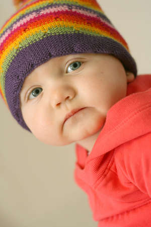 Adorable baby girl with colorful hat and cute faceの写真素材