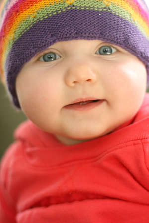 Smiling baby girl with colorful hatの写真素材