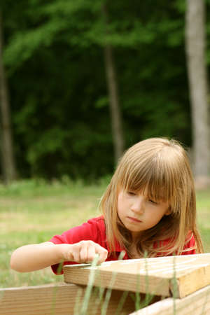 Little girl playing alone outdoorsの写真素材