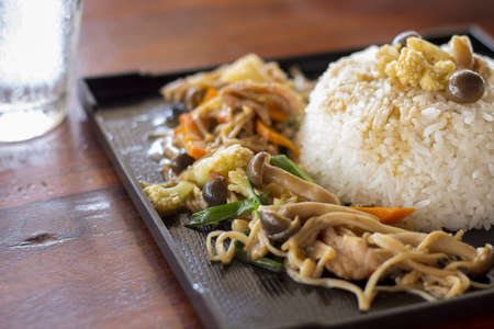 Mushrooms stir fry with rice on black plateの写真素材