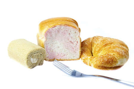 Sliced Wheat Bread and Croissants  Cake roll on white backgroundの写真素材