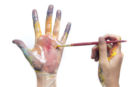 Beautiful little girl with hands in the paintの写真素材