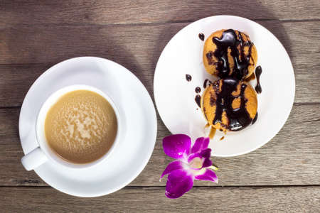 Coffee and sweets to tasty on a wooden floorの写真素材