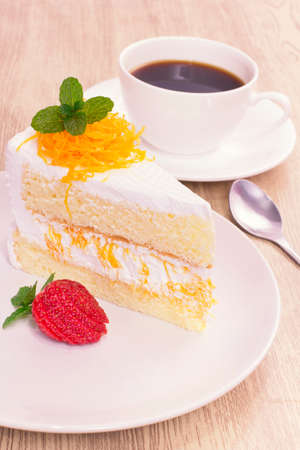 cake on the white plate with a cup of coffeeの写真素材