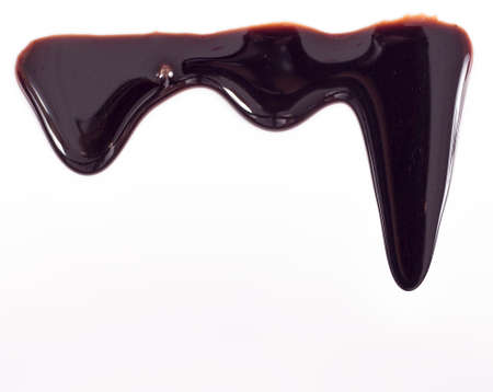 Melted chocolate dripping on white backgroundの写真素材
