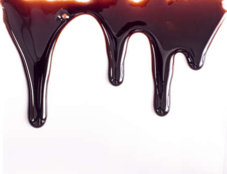 Melted chocolate dripping on white backgroundの写真素材