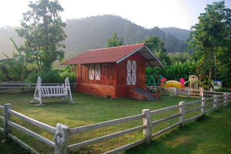 red barn in the mountain farm with white fenceのeditorial素材