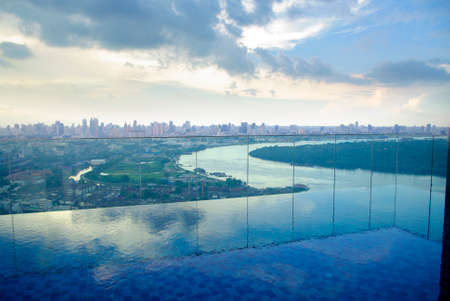 infinity pool on high condominuim building. beautiful view of river and city skyline