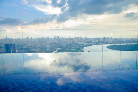 infinity pool on high condominuim building. beautiful view of river and city skylineの写真素材