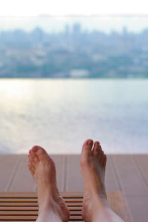 women feet relax at the high rise infinity pool