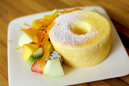 sponge cake with orange and tropical fruitsの写真素材