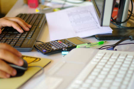 busy working desk hand and keyboardの写真素材
