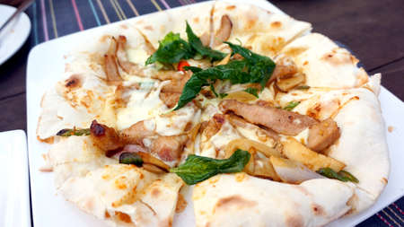 Italian Thai India fusion pizza style, prol with basil on nan pizza breadの写真素材