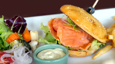 smoked salmon burger with beautiful salad decorationの写真素材