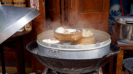 hot fresh steaming dimsum and dumplings at classic wooden restuarant in Asiaの写真素材
