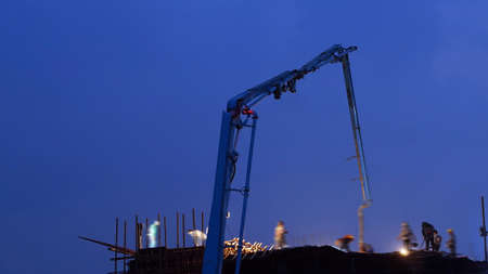 concrete pump working at night with blue sky and sillhoutteの写真素材